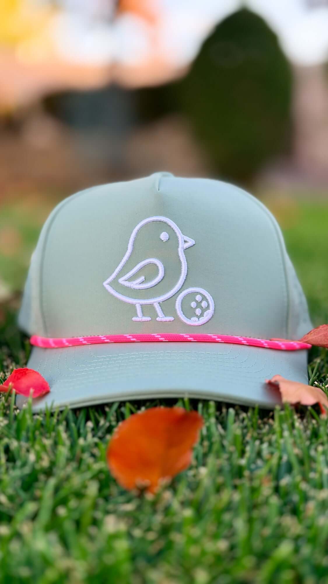 Green cap with a white logo on grass