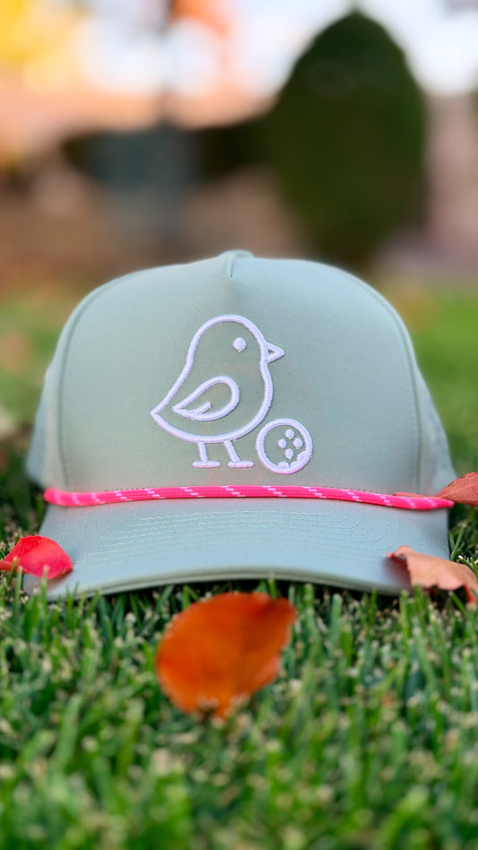 Green cap with a white logo on grass